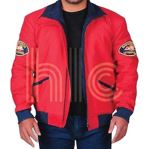 Könnte beinhalten: Eine rote Bomberjacke mit blauem Kragen und Ärmelbündchen. Die Jacke hat zwei Taschen vorne und zwei Aufnäher auf der Brust, auf denen "Baywatch Lifeguard" steht.