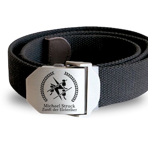 May include: Black canvas belt with a silver buckle. The buckle features a graphic of a person being electrocuted with the text "Michael Struck Zunft der Elektriker".