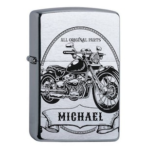 Könnte beinhalten: Silberner Feuerzeug mit einer schwarz-weißen Illustration eines Motorrads mit dem Text "ALL ORIGINAL PARTS" und "MICHAEL" darauf.