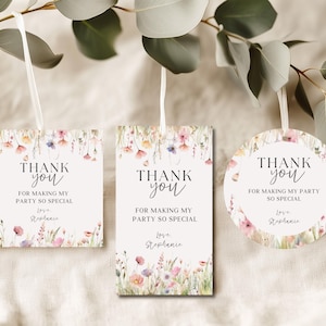 Può includere: Tre etichette di ringraziamento con disegni floreali e nastri bianchi. Le etichette sono di forma quadrata, rettangolare e circolare. Ogni etichetta presenta le parole "Thank You" e "For Making My Party So Special" con un nome sotto. Le etichette sono decorate con fiori ad acquerello.
