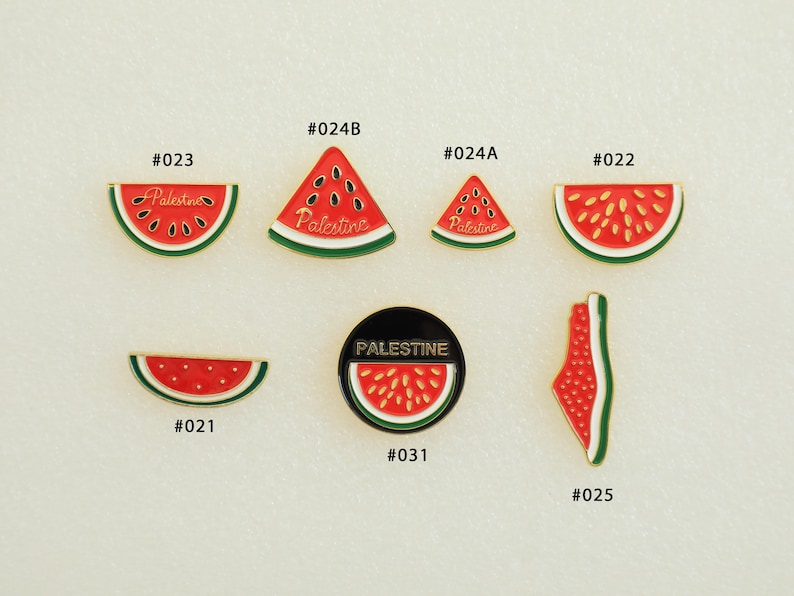 May include: A collection of watermelon-themed enamel pins. The pins feature red and green watermelon slices, triangles, and a round pin with the word "Palestine". Some pins have the word "Palestine" written on them.