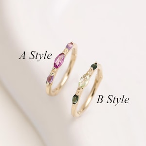 Peut inclure: Deux bagues en or étiquetées A Style et B Style. La bague A Style présente des pierres roses taille marquise, tandis que la bague B Style présente des pierres vertes taille marquise. Les deux bagues ont un anneau fin avec des sertis délicats.