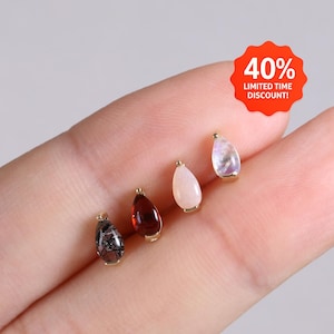 May include: Four small teardrop-shaped charms in gold settings, featuring a black rutilated stone, a deep red garnet, a smooth pale pink stone, and a translucent iridescent stone. A red circular badge displays the text 40% LIMITED TIME DISCOUNT!