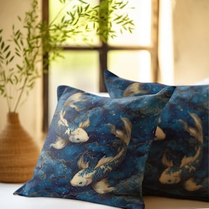 May include: Three square throw pillows with a blue background and a koi fish design. The pillows have a dark blue background with a pattern of gold swirls and white koi fish. The pillows are on a white surface.