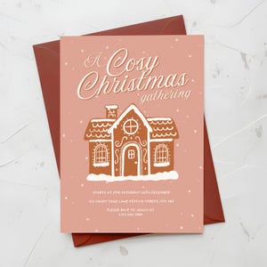 May include: A pink Christmas gathering invitation card with a gingerbread house illustration and the text "A Cosy Christmas gathering". The card includes event details: date, time, and RSVP information. The invitation is placed on a red envelope.