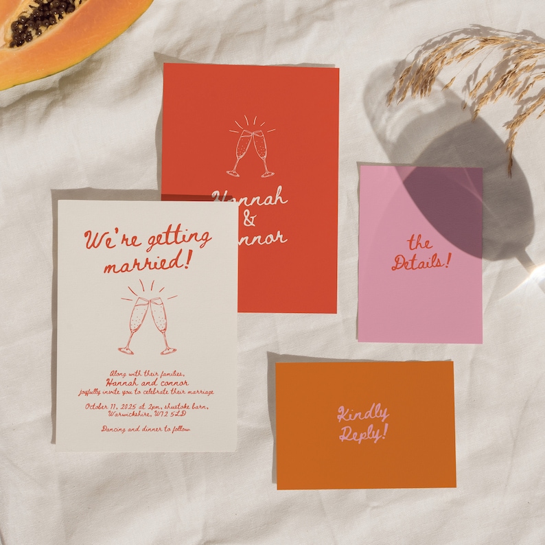 May include: A wedding invitation suite with a peach background. The main card is cream with red text that says "We're getting married!" and a graphic of two champagne glasses. The second card is red with white text that says "Hannah & Connor". The third card is pink with white text that says "the Details!" and the fourth card is orange with pink text that says "Kindly Reply!"
