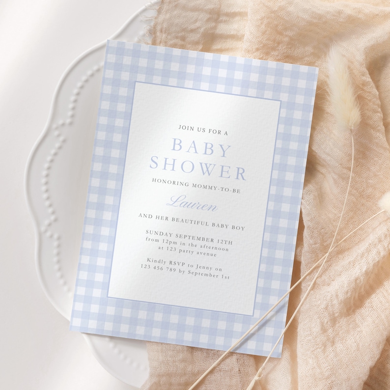 May include: A blue and white gingham baby shower invitation with the text "Join us for a Baby Shower honoring Mommy-to-be Lauren and her beautiful baby boy. Sunday September 12th from 12pm in the afternoon at 123 party avenue. Kindly RSVP to Jenny on 123 456 789 by September 1st."