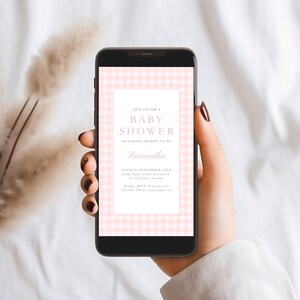 K&ouml;nnte beinhalten: Ein Handy-Bildschirm mit einem rosa-wei&szlig;en Gingham-Muster, auf dem eine Einladung zu einer Babyparty f&uuml;r Samantha angezeigt wird. Die Einladung enth&auml;lt Datum, Uhrzeit und Ort der Veranstaltung. Au&szlig;erdem wird um eine Antwort bis zum 1. September gebeten.