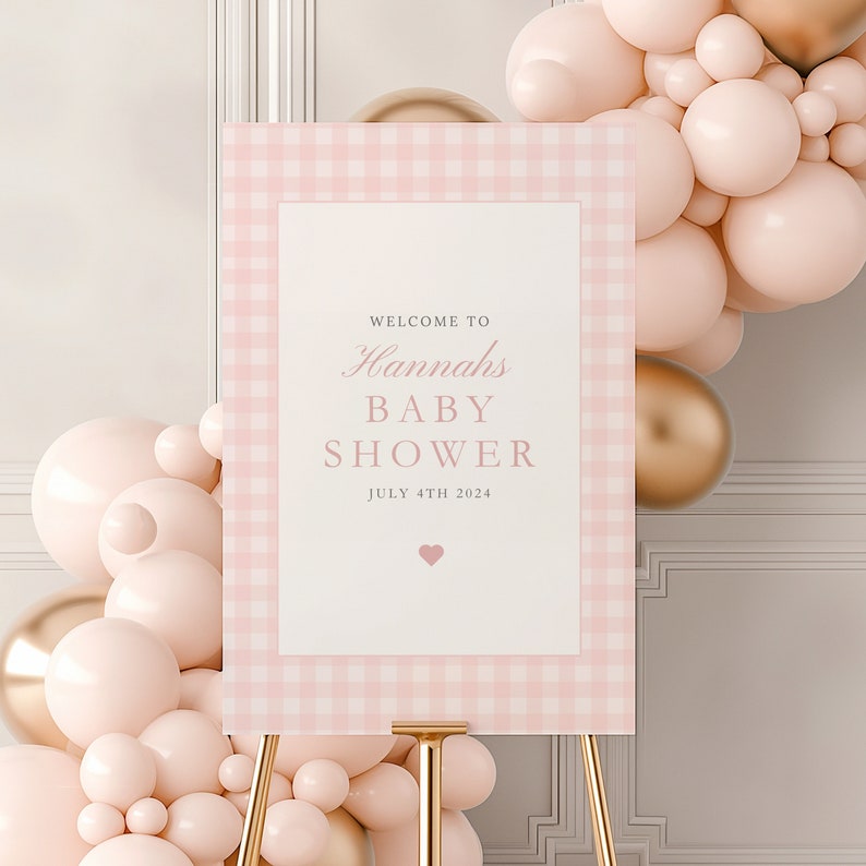 Może przedstawiać: R&oacute;żowo-biały ginghamowy znak powitalny na baby shower z tekstem "Witamy na baby shower Hannah 4 lipca 2024" i małym r&oacute;żowym sercem.
