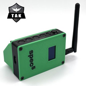 May include: A green and black electronic device with a small screen and a black antenna. The device has the text "spec5" printed on the side.