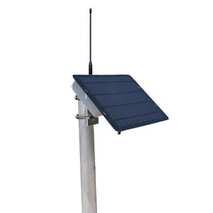 May include: A rectangular solar panel with a dark blue grid pattern mounted on a silver metal pole. A thin black antenna extends vertically from the top of the panel housing. The unit is secured to the pole with a metal clamp and bracket assembly.