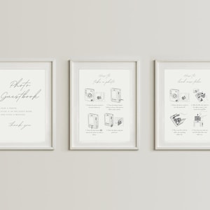 May include: Three white framed prints with black and white illustrations of a camera and instructions on how to take a photo and load new film. The text on the left print reads "Photo Guestbook. Snap a photo, stick it in the guest book and leave a message. Thank you".