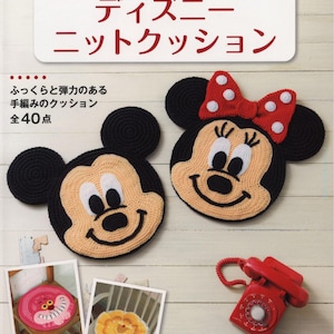 May include: A book cover featuring a crocheted Mickey Mouse and Minnie Mouse cushion. The book title is "Disney Knit Cushions" and the text says "40 total projects".