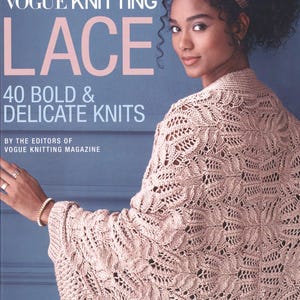 Puede incluir: Una portada de libro con una mujer que lleva una chal de punto de encaje rosa claro delicado. El título del libro es "Vogue Knitting Lace: 40 Bold & Delicate Knits" y el subtítulo es "By the Editors of Vogue Knitting Magazine".