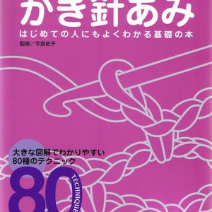 Puede incluir: Una portada de libro rosa con texto e ilustraciones en japonés. El título "かぎ針あみ" es prominente, con texto adicional y el número "80" en un círculo púrpura. El libro es una guía de técnicas de ganchillo.