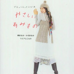 May include: A book cover with Japanese text and a woman wearing a knitted hat, scarf, and dress. The text includes "Let's knit series" and "Natural". The woman is smiling and wearing brown boots.