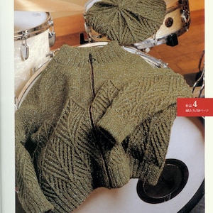 May include: A green knitted cardigan with a zipper closure and a diamond pattern. The cardigan is laid out on a drum.