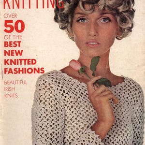Könnte beinhalten: Vogue Knitting Magazin-Cover aus Frühjahr/Sommer 1968 mit einer Frau, die ein weißes Häkeltop trägt und eine rosa Rose hält. Der Covertext lautet "Über 50 der besten neuen Strickmoden, wunderschöne irische Strickwaren".