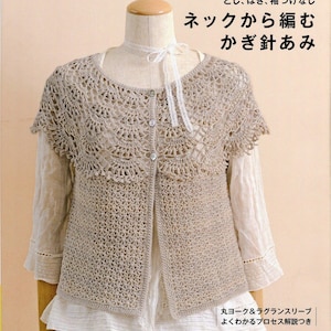 May include: A beige crochet cardigan with a round neckline and short sleeves. The cardigan is made with a delicate stitch pattern and has a button closure. The text "Top-Down Crochet" and "ネックから編む かぎ針あみ" is visible in the image.