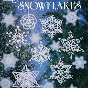 May include: Crocheted snowflake patterns from the American School of Needlework, Book 1025(25), by Mary Thomas. Seven white crocheted snowflakes are shown against a blue and white snowy background.