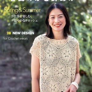 Könnte beinhalten: Ein Häkelmusterbuch mit einer Frau, die ein gehäkeltes Oberteil mit Blumenmuster trägt. Der Buchtitel lautet "Frühling & Sommer" und enthält den Text "28 NEUE DESIGNS für Häkelkleidung".