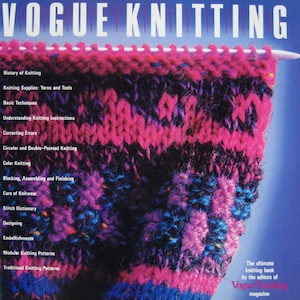 May include: The cover of "Vogue Knitting" magazine displays a close-up of vibrant knitted fabric in pink, purple, blue, and black. The magazine title is at the top, with a list of contents and the tagline "The ultimate knitting book" by the editors.