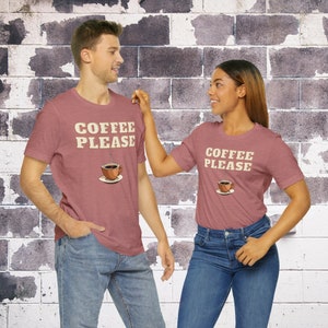 May include: Two people wearing matching maroon t-shirts with the text "Coffee Please" and a cartoon coffee cup graphic.