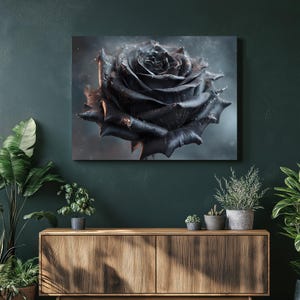 Op de afbeelding: Een close-up van een zwartroosprint op canvas. De roos heeft gedetailleerde bloemblaadjes met een donkere, sfeervolle uitstraling. Het kunstwerk is gemonteerd op een houten frame, geschikt voor wanddecoratie. De achtergrond is zacht en wazig.