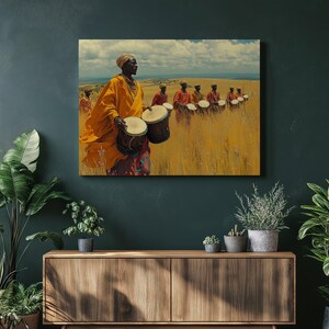 May include: A canvas print depicts a group of people in a field. The foreground features a person in an orange robe holding two drums. Other people in red robes are in the background, also holding drums. The sky is blue with white clouds.