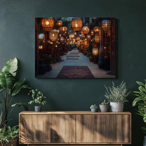 May include: A canvas print depicting a vibrant alleyway illuminated by numerous ornate, glowing lanterns. The lanterns, in various shapes and sizes, cast a warm, inviting light. The scene includes rugs and potted plants, creating a cozy, exotic atmosphere. The color palette is dominated by warm oranges and browns.