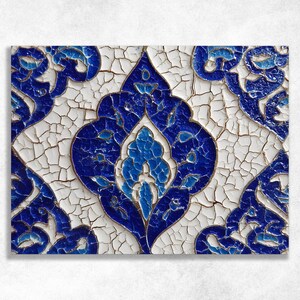 May include: Close-up of a decorative tile with a symmetrical floral design. The design features shades of blue and white, with gold accents. The tile has a distressed, cracked appearance, adding to its vintage aesthetic.
