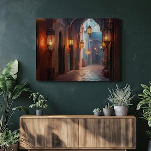 May include: A canvas print depicting a Middle Eastern alleyway at dusk. The scene features a cobblestone street lined with archways and hanging lanterns. The warm glow of the lanterns contrasts with the cool blue hues of the sky, creating a captivating ambiance.