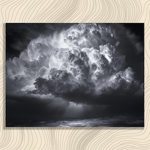 Puede incluir: Fotografía en blanco y negro de una nube de tormenta sobre el océano. La nube es grande y abultada, con reflejos blancos brillantes y sombras oscuras. El océano debajo está agitado, con olas visibles. La imagen es un estudio de contrastes.