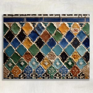 May include: Close-up of a decorative tile panel featuring a repeating diamond pattern. The tiles are in various colors, including blue, green, yellow, and black. The top and bottom borders have floral designs.