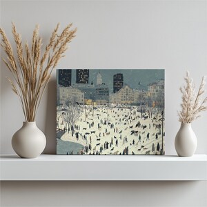 May include: A canvas print depicting a snowy city scene with numerous people and dogs. Buildings and trees are visible in the background, with a soft, muted color palette. The artwork is displayed on a white shelf with vases of dried plants.