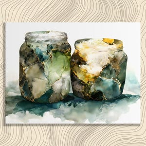 Op de afbeelding: Twee aquarelpotten met een marmereffect. De potten hebben tinten groen, blauw en goud, met een textuur. De potten zijn gevuld met een witte substantie en staan op een aquarelachtergrond.