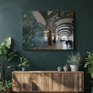 May include: A framed canvas print of a long arched hallway with people walking. The walls are decorated with blue and white tiles depicting a landscape. The ceiling is arched and painted with decorative elements. The hallway is lit by overhead lights.