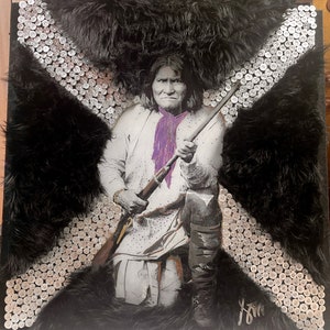 May include: A black and white portrait of a Native American man holding a rifle. The portrait is framed with black fur and silver bullet casings.