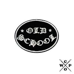 Könnte beinhalten: Schwarz-weiß gestickter Aufnäher mit dem Text "OLD SCHOOL" in gotischer Schrift.