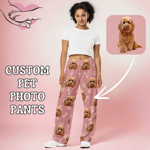 Puede incluir: Pantalón de pijama rosa con un patrón repetido de la cara de un perro y un hueso.  "CUSTOM PET PHOTO PANTS" está escrito en blanco sobre un fondo rosa.