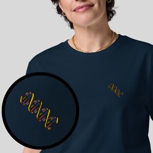May include: Navy blue t-shirt with an embroidered DNA helix design in yellow, red, purple, and blue. The shirt features a small, detailed DNA helix on the chest. A color palette of available shirt colors is shown on the right.