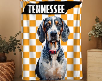 May include: A Tennessee-themed blanket featuring a hound dog illustration. The blanket has a yellow and white checkered background with the word "TENNESSEE" in bold white letters on a black background. The dog has black, white, and brown fur and is wearing a blue collar with a red buckle.
