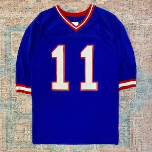 May include: A blue football jersey with white and red trim. The number "11" is printed on the front in white with a red outline.