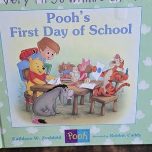 Puede incluir: Portada del libro infantil "Very First Winnie the Pooh: Pooh's First Day of School". La ilustración muestra a Winnie the Pooh, Tigger, Piglet, Eeyore y Christopher Robin en una mesa. Autora: Kathleen W. Zoehfeld.