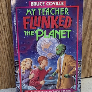 May include: A paperback book titled "My Teacher Flunked the Planet" by Bruce Coville. The cover features a green alien teacher, two children, and a planet Earth illustration. The book is a sequel to "My Teacher is an Alien".