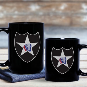 May include: Two black ceramic mugs with a white star and Native American head design. The larger mug is on a blue denim coaster.