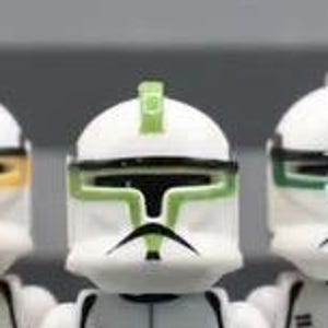 May include: Eight toy figures in a row, each with a white helmet and a different coloured trim. The helmets have accents in red, pink, orange, yellow, green, blue, and purple. The figures are in a line, with grey and white uniforms.