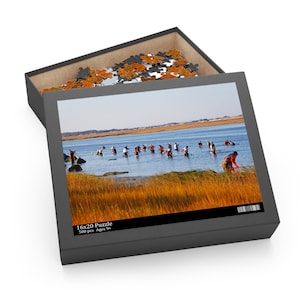 May include: A 500 piece jigsaw puzzle with a picture of people wading in a shallow body of water. The puzzle box is open and shows the puzzle pieces. The box has the text "16x20 Puzzle 500 pcs Ages 9+"