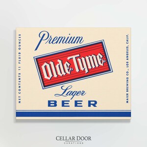 Peut inclure: Une étiquette de bière de style vintage avec le texte "Premium Olde Tyme Lager Beer". L'étiquette présente un design rouge et blanc avec des accents bleus, et le texte "NET CONTENTS 325 ml". Les mots "CELLAR DOOR CURATIONS" sont en bas.