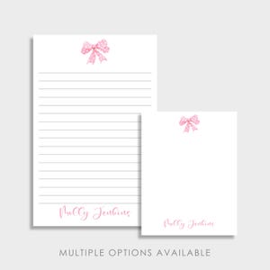 May include: White stationery set featuring a pink polka dot bow design. The set includes a lined notepad and a smaller blank note card. The name "Molly Jenkins" is printed in pink script at the bottom of each. "MULTIPLE OPTIONS AVAILABLE" is printed at the bottom.